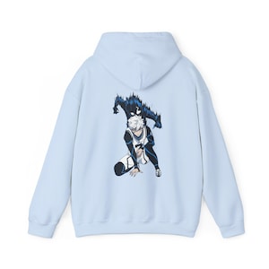 May include: A light blue hoodie featuring a graphic print of a character from an anime or manga. The character has white hair and is wearing a white and black outfit. The character is surrounded by a dark blue shadow.