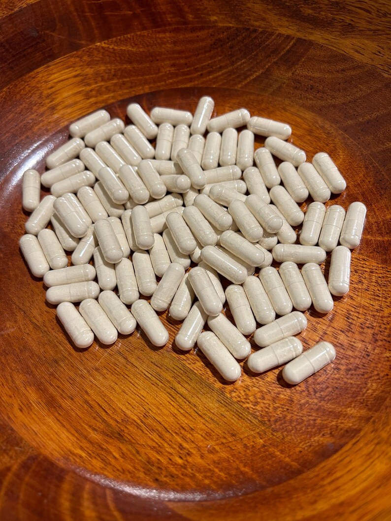 May include: A wooden bowl filled with a large quantity of white capsules.