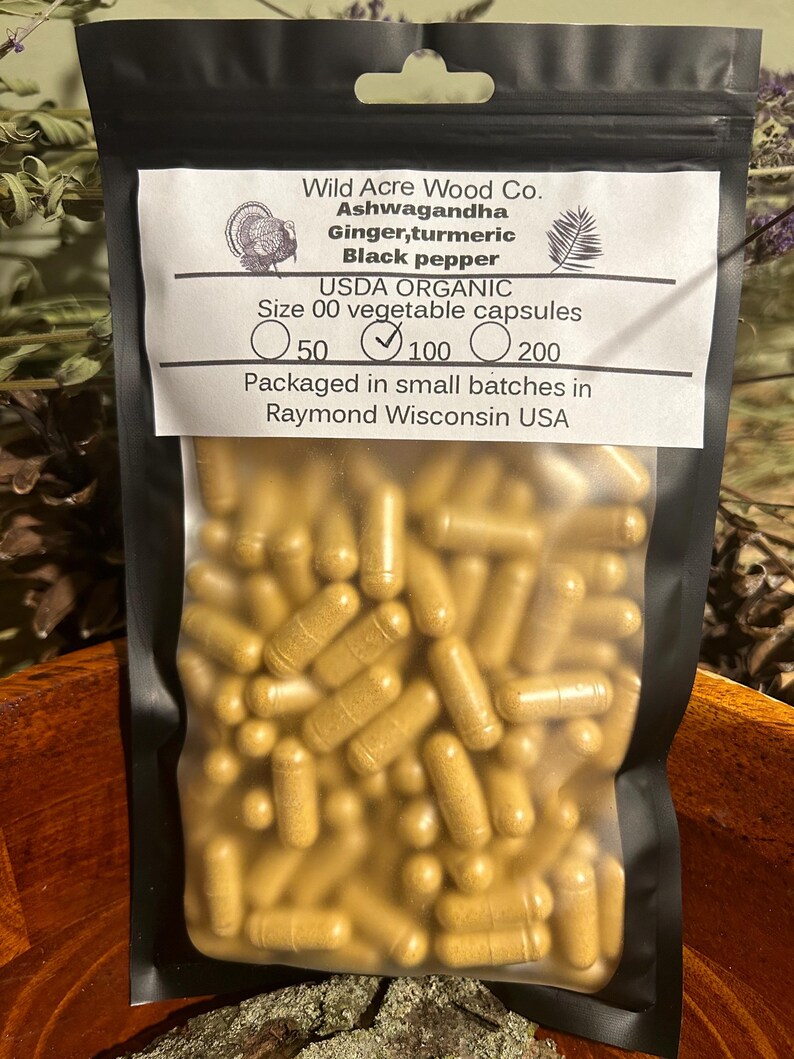 Peut inclure: Un sac en plastique transparent rempli d'une grande quantit&eacute; de capsules jaunes dor&eacute;es. Le sac est &eacute;tiquet&eacute; "Wild Acre Wood Co. Ashwagandha Gingembre, curcuma Poivre noir USDA ORGANIC Taille 00 capsules v&eacute;g&eacute;tales 50 100 200 Conditionn&eacute; en petits lots &agrave; Raymond Wisconsin USA"