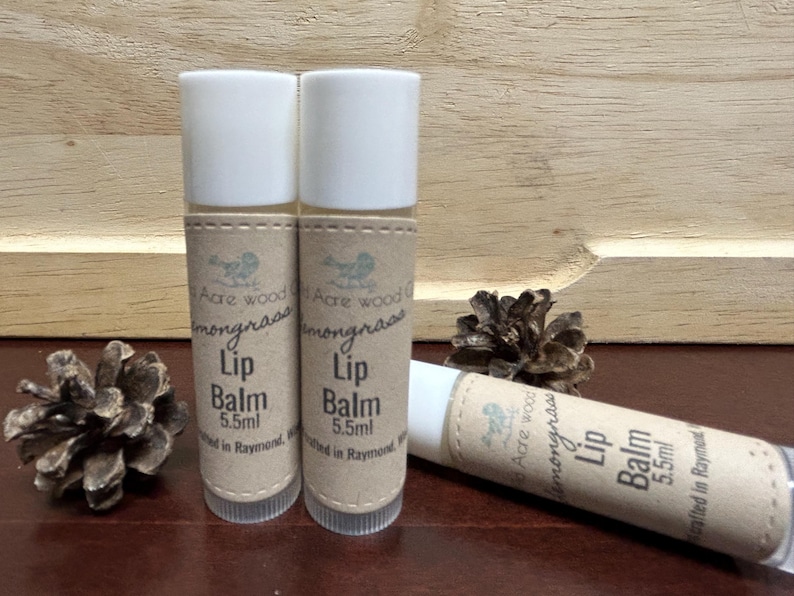 May include: Three brown and white lip balm tubes with a label that reads "Acre Wood Lemongrass Lip Balm 5.5ml Crafted in Raymond, WA".
