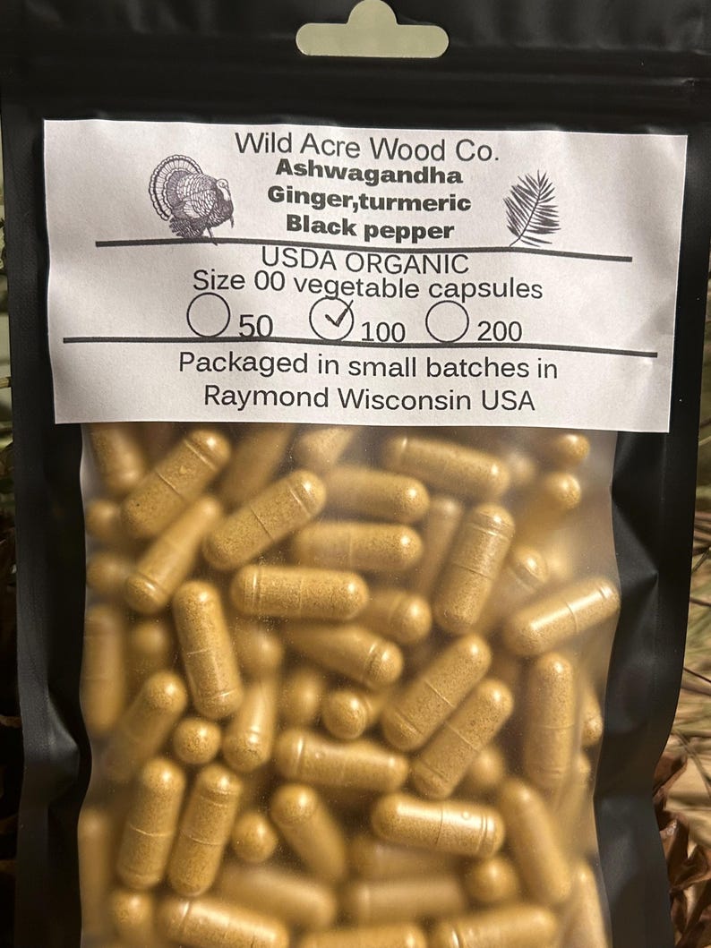 Peut inclure: Un sac en plastique transparent rempli d'une grande quantit&eacute; de capsules brunes. Le sac porte une &eacute;tiquette sur laquelle est inscrit "Wild Acre Wood Co. Ashwagandha Ginger, turmeric Black pepper USDA ORGANIC Size 00 vegetable capsules 50 100 200 Packaged in small batches in Raymond Wisconsin USA".