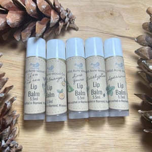 May include: Five small, white tubes of lip balm with brown labels. The labels have different scents, including Tea Tree, Orange, Lime, Eucalyptus, and Spearmint. Each tube is 5.5 ml and hand-crafted in Raymond, Wisconsin.