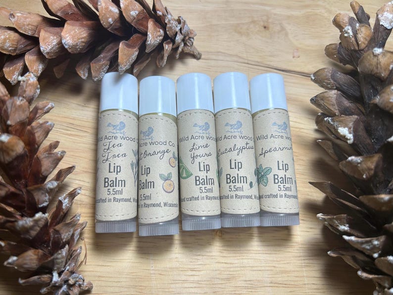 May include: Five small, white tubes of lip balm with brown labels. The labels have different scents, including Tea Tree, Orange, Lime, Eucalyptus, and Spearmint. Each tube is 5.5 ml and hand-crafted in Raymond, Wisconsin.