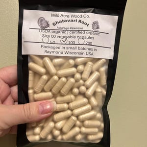 May include: A resealable bag filled with beige capsules labeled "Shatavari Root Asparagus Racemosus USDA organic | certified organic Size 00 vegetable capsules 50 100 200 Packaged in small batches in Raymond Wisconsin USA"