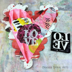 May include: A pink and red heart-shaped paper craft with the word "LOVE" in white letters and the word "XOXO" in black letters. The heart is decorated with paint and other mixed media.
