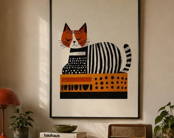 May include: A framed wall art print featuring a stylized cat with a rust-colored head and a black and white striped body, resting on a rectangular base with orange and black geometric patterns, displayed in a living room setting.