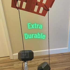 May include: An orange weight rack with two black dumbbells, each weighing 30 pounds, suspended by black ropes. The text "Built to Last" and "Extra Durable" are visible. The total weight is 60 pounds.