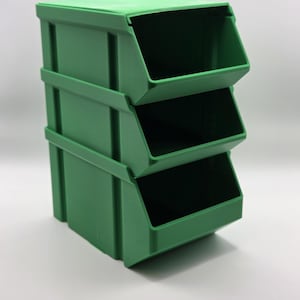 Op de afbeelding: Een stapel van drie groene plastic opbergbakken. Elke bak heeft een open voorkant voor gemakkelijke toegang. De bakken zijn ontworpen voor modulaire opslag. Ze zijn gemaakt van duurzaam kunststof materiaal.