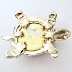May include: A silver turtle trinket box with a round, gold-colored interior. The turtle has a detailed shell and four legs.