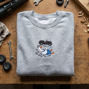 May include: A white ceramic mug with a black handle and the text "But First, Coffee" in a black, bold font. The mug is on a white surface. The mug is approximately 4 inches tall.