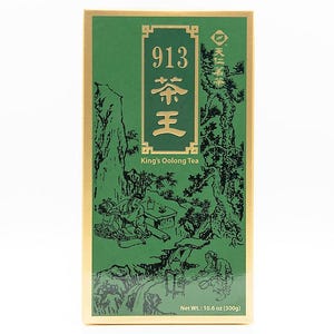 Könnte beinhalten: Eine grüne und goldene Schachtel mit King's Oolong Tee. Auf der Vorderseite der Schachtel befindet sich die goldene Zahl "913", zusammen mit chinesischen Schriftzeichen und den Worten "King's Oolong Tea". Die Schachtel zeigt auch eine Schwarz-Weiß-Illustration von Menschen in einer Landschaft.