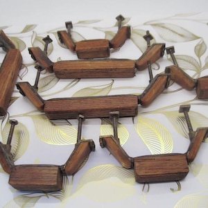 May include: A collection of antique wooden furniture hardware, featuring a warm brown finish. Each piece has a rectangular central block with angled side pieces and metal hardware. The hardware includes screws and brackets, suggesting a vintage aesthetic.