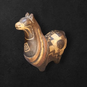 Puede incluir: Figura de llama marrón con detalles dorados y rojos. La llama tiene patrones geométricos en su cuerpo y cara. La figura está hecha de un material oscuro y tiene un acabado liso. La llama está de pie sobre sus cuatro patas.