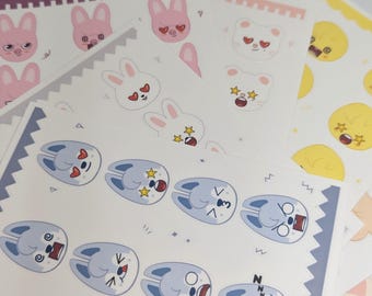 May include: Sheets of stickers featuring various cartoon animal faces with different expressions. The stickers include bunnies, pigs, cats, and ducklings in pink, white, yellow, and blue. The stickers have a white background.