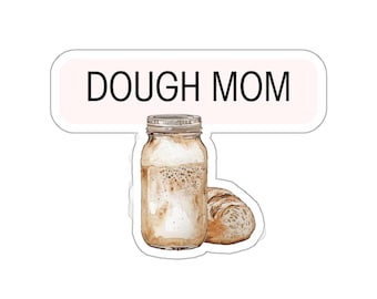 May include: A sticker with the text "DOUGH MOM" in black letters on a pink background. Below the text is a brown glass jar with a white lid filled with a brown liquid and a brown bread roll.