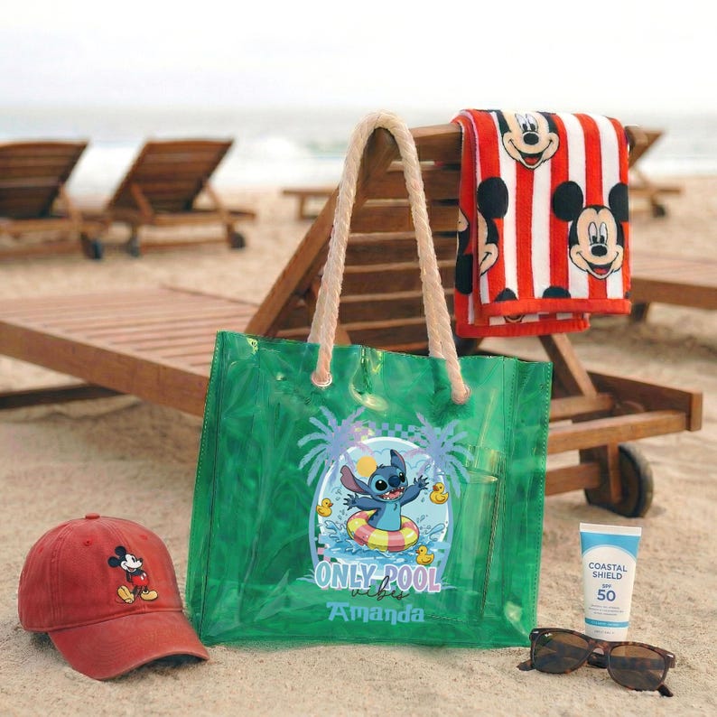 May include: A beach scene with a red baseball cap featuring Mickey Mouse, a green tote bag with Stitch, a red and white striped towel with Mickey Mouse, sunglasses, and sunscreen. The tote bag says "ONLY POOL" and "Amanda".