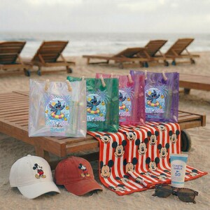 May include: Beach-themed items including clear tote bags with Stitch graphics, a Mickey Mouse beach towel, baseball caps, sunglasses, and sunscreen. The bags have rope handles and the text "ONLY POOL vibes".