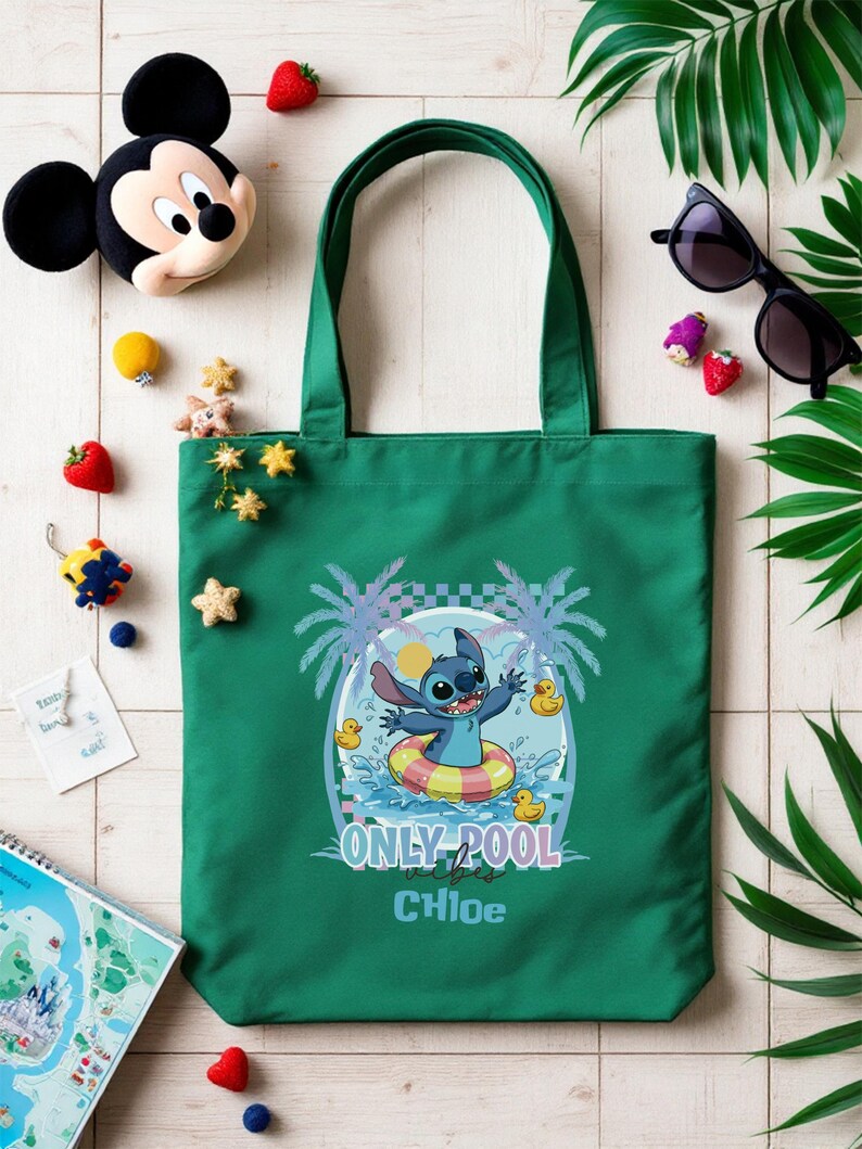 May include: A green tote bag featuring a cartoon Stitch character in a pool float with the text "ONLY POOL vibes" and the name "Chloe". The bag is surrounded by decorative elements including a Mickey Mouse plush, sunglasses, and tropical leaves.