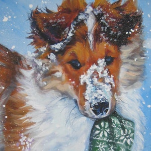 以下が含まれることがあります： 雪景色の中のシェットランドシープドッグの油絵。犬は茶色と白の毛並みで、顔に雪が付いています。緑と白の模様の靴下を口にくわえています。アーティストのサイン「L.A. SHEPARD ART」が見えます。