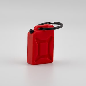 May include: A small, red, rectangular keychain resembling a fuel canister. It has a black handle and a black cap. The keychain is a miniature version of a fuel container.