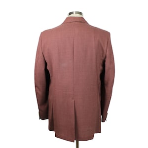 May include: A dusty rose blazer with a single button closure and long sleeves. The blazer is made of a textured fabric and has a classic fit.