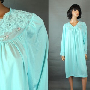 May include: A light blue, long-sleeved nightgown with a lace trim around the neckline and cuffs. The neckline has a scalloped edge and the gown has a gathered bodice.