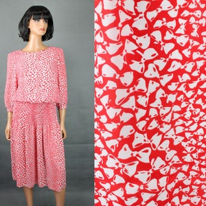 Puede incluir: Un vestido rojo y blanco con estampado de lazos. El vestido tiene un corpiño ajustado y una falda fluida.