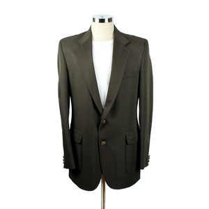 Op de afbeelding: Een donkerbruin blazer met een enkele knoopsluiting en twee klepzakken. De blazer heeft een klassieke, getailleerde pasvorm.