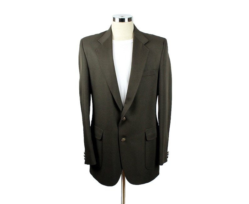 Op de afbeelding: Een donkerbruin blazer met een enkele knoopsluiting en twee klepzakken. De blazer heeft een klassieke, getailleerde pasvorm.
