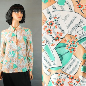 May include: A peach-colored blouse with long sleeves and a button-up collar. The blouse features a repeating pattern of musical notes, flowers, and a green musical instrument.