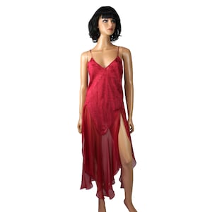 Puede incluir: Un vestido rojo con tirantes finos y cuello en V. El vestido presenta un corpiño texturizado y una falda fluida y transparente con aberturas altas. El vestido se exhibe en un maniquí.