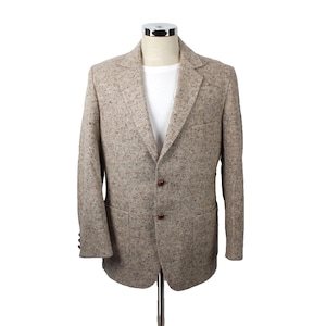 May include: A tan tweed blazer with a two-button closure, notched lapels, and two front pockets. The jacket is displayed on a mannequin against a white background. The blazer has a classic, tailored fit.
