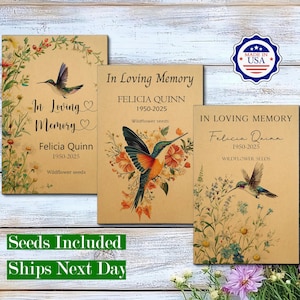 May include: Three rectangular seed packets made of tan paper, each featuring the text In Loving Memory, Felicia Quinn, 1950-2025, and Wildflower seeds. The designs include colourful illustrations of hummingbirds and various wildflowers.