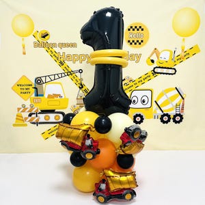 Puede incluir: Un globo negro con forma de número uno con anillos amarillos a su alrededor, rodeado de globos amarillos, naranjas y negros. También hay pequeños camiones de volteo de juguete en la imagen. El fondo es un telón de fondo de construcción amarillo y blanco con el texto "Balloon queen to my party Happy Jay" y "Welcome to my party".