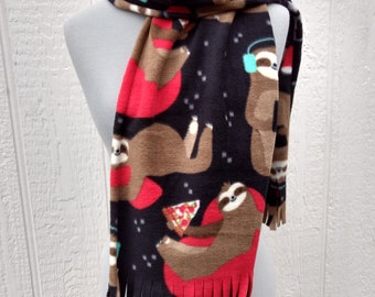 May include: A black fleece scarf with a pattern of brown sloths wearing headphones, eating pizza, and relaxing in red lounge chairs. The scarf has fringe on the bottom.