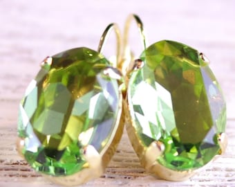 May include: A pair of gold earrings with large, oval-shaped, green gemstones.