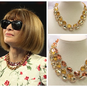 May include: Two necklaces with large, faceted, oval-shaped crystals. The top necklace is a single strand of yellow and orange crystals. The bottom necklace is a double strand of orange and yellow crystals.