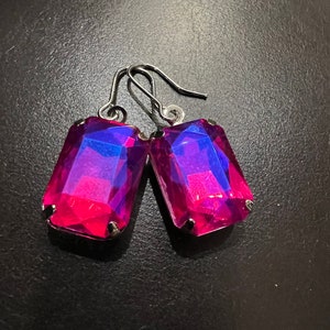 May include: A pair of silver dangle earrings with large, rectangular, iridescent pink and blue gemstones.