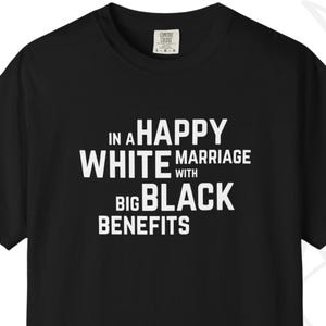 May include: Black t-shirt with white text that reads "IN A HAPPY WHITE MARRIAGE WITH BIG BLACK BENEFITS". The shirt has short sleeves and a crew neck. The brand logo "BSA BOLD SWING APPAREL" is at the bottom left.