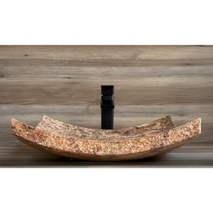 May include: A curved, brown and beige stone vessel sink with a black faucet.