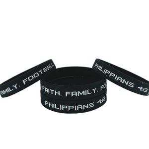 May include: Three black silicone wristbands with white text. The bands read "Family. Football", "Faith. Family. Football", and "Philippians 4:13".