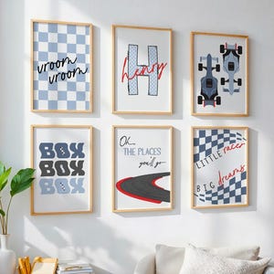 May include: Six framed wall art prints with a racing theme. Prints include checkered patterns, race cars, and phrases like "vroom vroom", "BOX BOX BOX", and "Little race, big dreams". The frames are light wood.