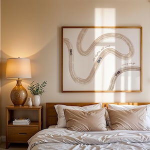 May include: A bedroom scene featuring a wooden bed frame with pillows and a comforter. A framed artwork with a race track design and the text "it's lights out and away we go" hangs above the bed. A lamp and nightstand are on the left.