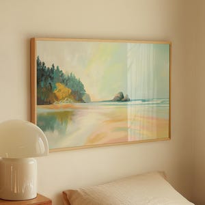 Könnte beinhalten: Ein gerahmtes Landschaftsgemälde mit einer Strandszene hängt über einem Bett. Eine weiße pilzförmige Lampe steht auf einer Holzkommode. Das Bett hat ein beiges Kissen und weiße Bettwäsche.