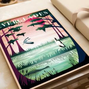 May include: A framed Everglades National Park art print. The illustration features a sunset, trees, birds, and an alligator in a swamp. The words "EVERGLADES National Park" are at the top of the print.