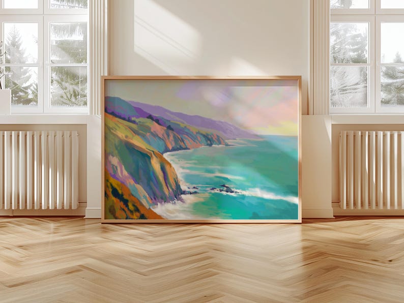 May include: A framed landscape painting depicts a coastal scene with cliffs, ocean, and sky. The artwork features vibrant colors, including shades of green, blue, purple, and orange. The painting is displayed on a wooden floor, with windows and radiators in the background.