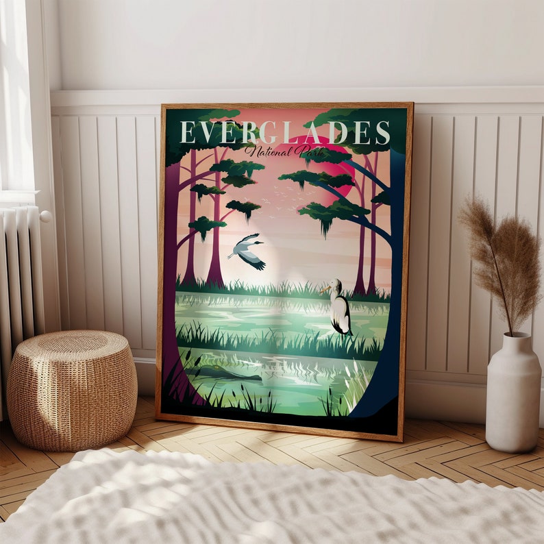 May include: A framed Everglades National Park poster. The artwork features a stylized landscape with a sunset, birds, and a body of water. The text "EVERGLADES National Park" is at the top. The frame is a warm brown color.