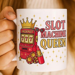 May include: White ceramic mug with a colorful design featuring a slot machine, sunglasses, lipstick, and gold coins. The mug has the text "SLOT MACHINE QUEEN" in pink and gold. The slot machine shows "777" for jackpot.
