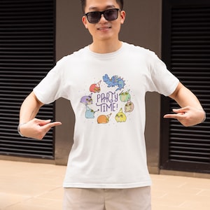 Puede incluir: Camiseta blanca con un gráfico de dinosaurios de dibujos animados coloridos que llevan sombreros de fiesta y el texto "Party Time!"
