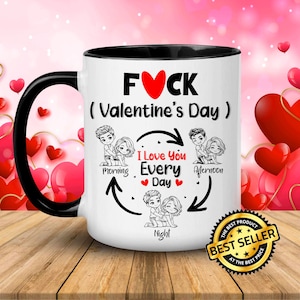 May include: White ceramic mug with a black handle and interior. The mug features the text "FUCK (Valentine's Day)" with a red heart. It also has illustrations of couples and the text "I Love You Every Day". A "Best Seller" sticker is on the mug.